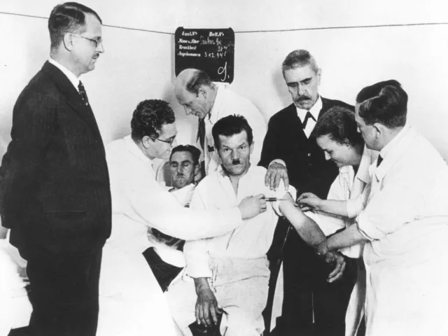 Julius von Wagner-Jauregg (1857–1940) mit Mitarbeitern an seiner Klinik bei einer Malariablutüberimpfung an einem Patienten