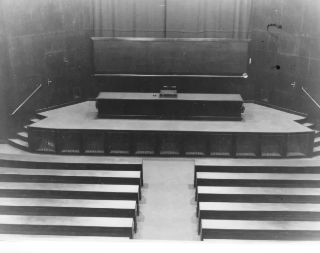 Das Auditorium Maximum im Hauptgebäude der Universität Wien, mit Blick auf das Podium, vor Anbringung von Doppeladler und Kr…